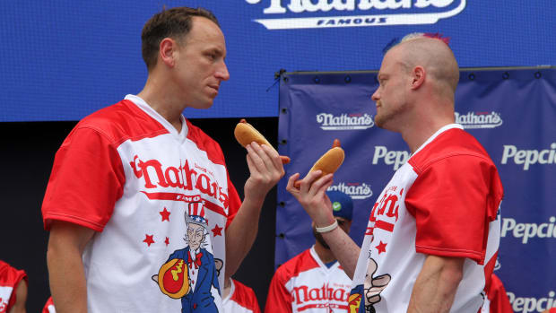 Hot dog eating competitors Joey Chestnut and Nick Wehry face off while holding hot dogs.