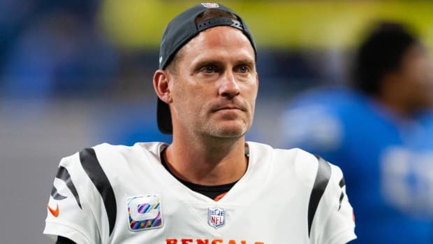 Bengals punter Kevin Huber looks on while wearing a backwards hat during a game.