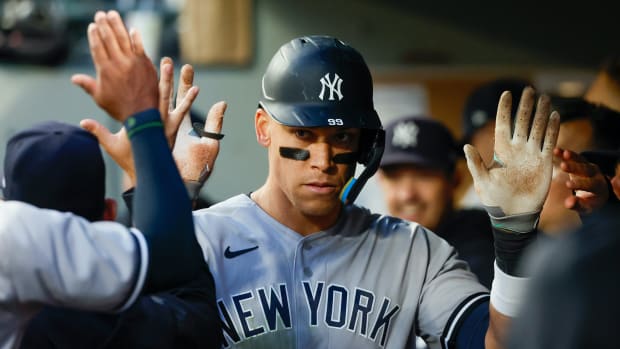 May 30, 2023; Seattle, Washington, USA; New York Yankees center fielder Aaron Judge (99) high-fives teammates in the dugout after hitting a solo-home run against the Seattle Mariners during the seventh inning at T-Mobile Park.