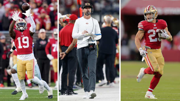 Deebo Samuel puts his hands up to catch the ball; Kyle Shanahan walks down the sideline holding a clipboard; Christian McCaffrey runs with the ball in one hand