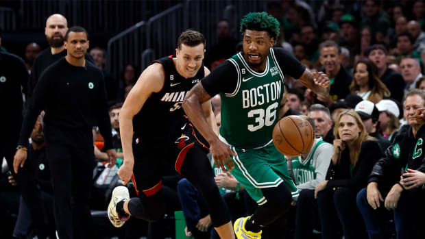 Marcus Smart dribbles past Duncan Robinson in the NBA playoffs.