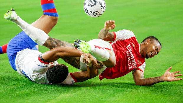Barcelona defender Ronald Araujo (left) and Arsenal forward Gabriel Jesus (right) both pictured on the ground after competing for the ball during a pre-season friendly in July 2023