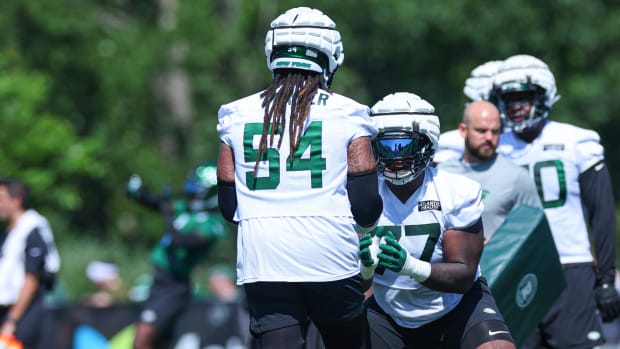 Jets offensive tackle Mekhi Becton (77) drills with guard Billy Turner (54) during training camp practice.