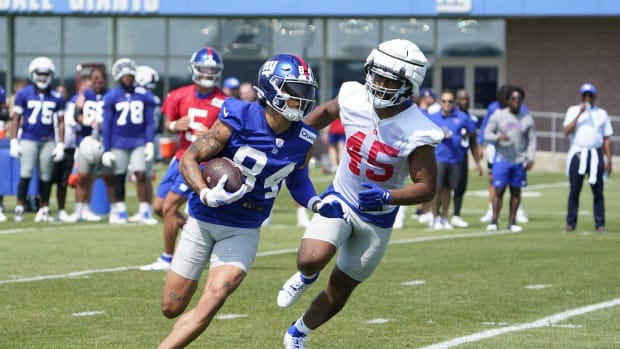 Jul 26, 2023; East Rutherford, NJ, USA; New York Giants rookie wide receiver Jalin Hyatt (84) runs with the ball with pressure from rookie linebacker Habakkuk Baldonado (45) on the first day of training camp at the Quest Diagnostics Training Facility.