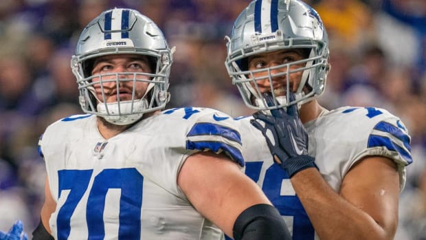 Cowboys offensive linemen Zack Martin and Terence Steele look up during a game.