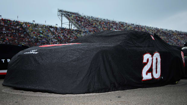 The #20 Toyota, driven by Christopher Bell, sits parked and covered on the grid during a weather delay prior to the NASCAR Cup Series FireKeepers Casino 400 at Michigan International Speedway on Sunday. The remainder of the race has been pushed back to Monday after running just 74 laps. (Photo by Jonathan Bachman/Getty Images)