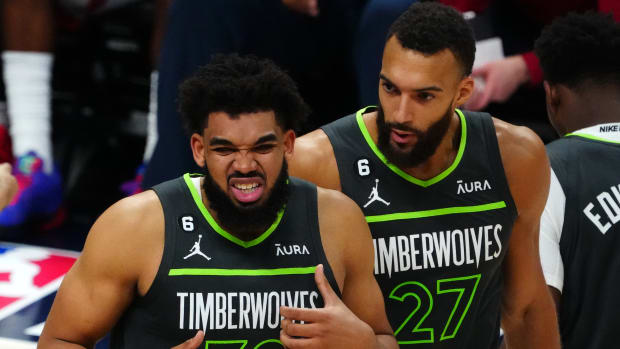 Minnesota Timberwolves center Karl-Anthony Towns grimaces with center Rudy Gobert behind him during the NBA Playoffs.