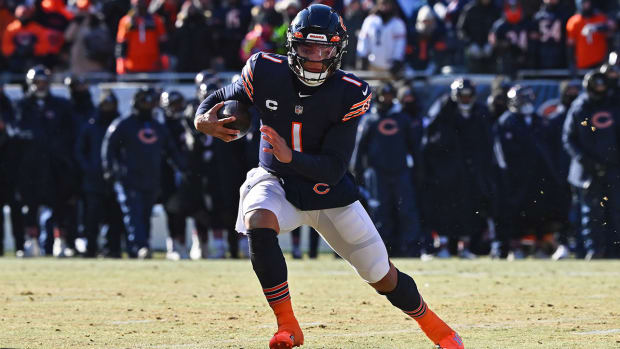Chicago Bears quarterback Justin Fields moves sideways as he holds the ball with one arm