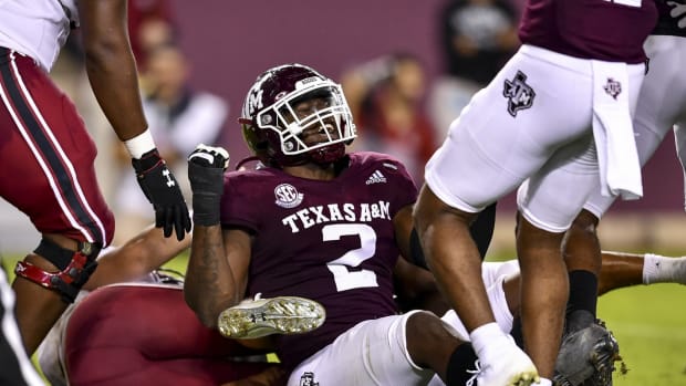 Texas A&M defensive lineman Micheal Clemons reacts to fumble