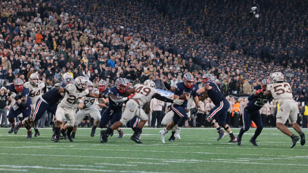 Navy runs a play vs. Army in front of a full stadium.