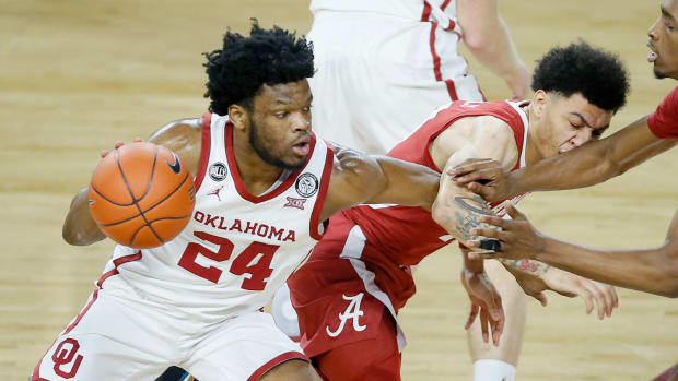 Oklahoma's Elijah Harkless (24) tries to get past Alabama's Jahvon Quinerly (13) during a basketball game at Lloyd Noble Center.