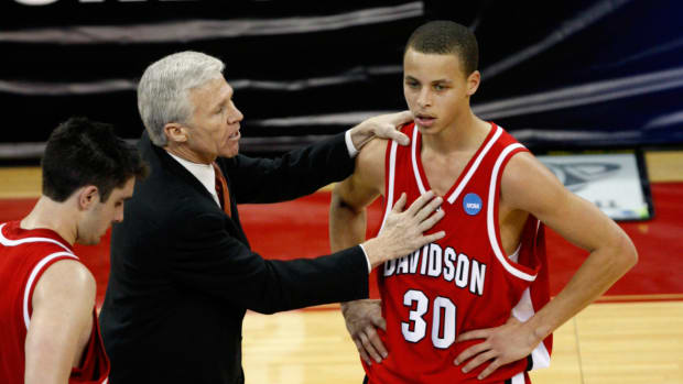 Davidson coach Bob McKillop speaks with Stephen Curry during game.