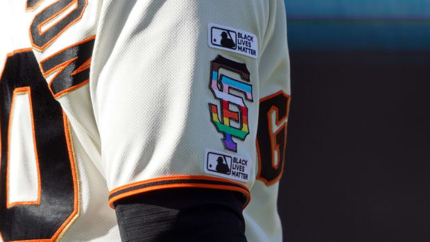 Close-up of Giants first base coach Antoan Richardson (00) wearing Black Lives Matter and LBGTQ+ themed logos on his uniform.