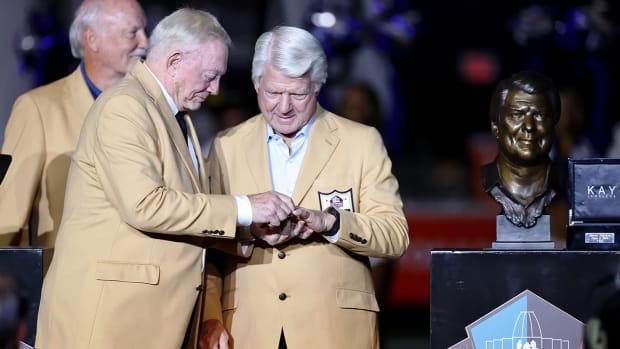 Jerry Jones puts the Hall of Fame ring on the finger of Jimmy Johnson during a presentation at halftime.