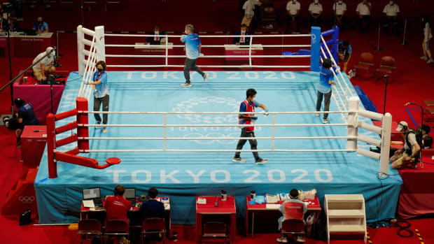 Jul 25, 2021; Tokyo, Japan; Volunteers sanitize the ring between bouts during the Tokyo 2020 Olympic Summer Games at Kokugikan Arena. Mandatory Credit: Michael Madrid-USA TODAY Network