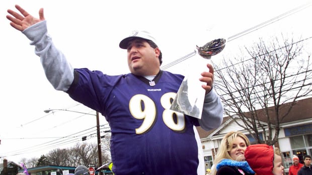 Tony Siragusa holds the Lombardi Trophy as he rides with his wife, Kathy, in a parade in his hometown of Kenilworth, New Jersey, on March 4, 2001.
