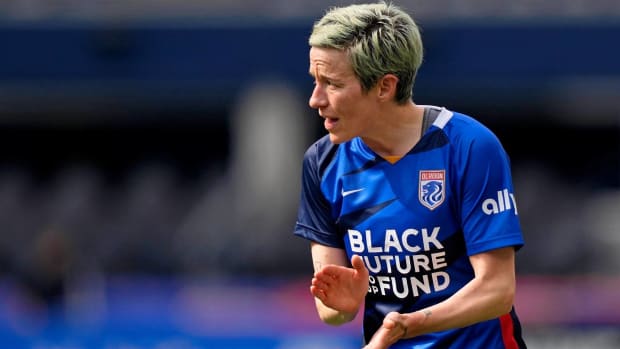Megan Rapinoe claps her hands in a game for OL Reign.
