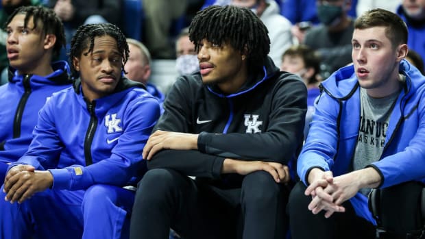 Kentucky guard Shaedon Sharpe sits on the Wildcats bench during a game.