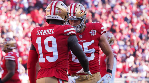Deebo Samuel and George Kittle embrace during a 49ers game.