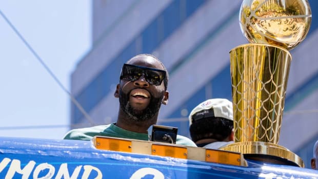 Golden State Warriors’ Draymond Green stands next to the Larry O’Brien trophy during the NBA Championship parade in San Francisco, Monday, June 20, 2022, in San Francisco. (AP Photo/John Hefti)