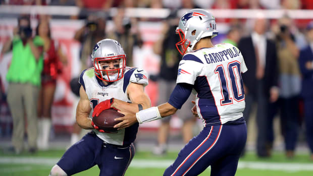 Patriots quarterback Jimmy Garoppolo (10) hands the ball off to wide receiver Julian Edelman (11) against the Cardinals.