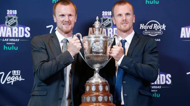 FILE - Daniel Sedin, right, and Henrik Sedin pose with the King Clancy Memorial Trophy after winning the award at the NHL Awards, Wednesday, June 20, 2018, in Las Vegas. Swedes Henrik and Daniel Sedin and Daniel Alfredsson have been elected to the Hockey Hall of Fame. Goaltender Roberto Luongo, Finnish women’s star Riikka Sallinen and builder Herb Carnegie were also selected Monday, June 27, 2022, to be inducted in November. (AP Photo/John Locher, File)