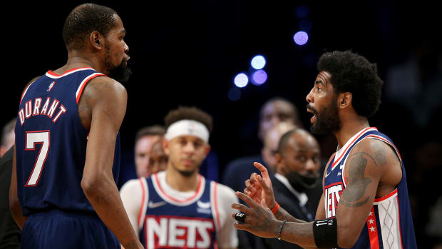 Nets guard Kyrie Irving (11) talks to forward Kevin Durant (7) during a game against the Celtics.