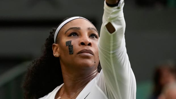 Serena Williams serves to France's Harmony Tan in a first round women's singles match at Wimbledon.
