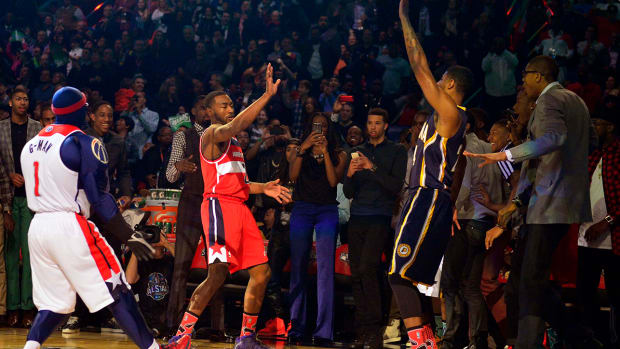 Wizards guard John Wall (2) and Pacers forward Paul George (24) reacts after Wall’s dunk during the 2014 NBA All Star dunk contest at Smoothie King Center.