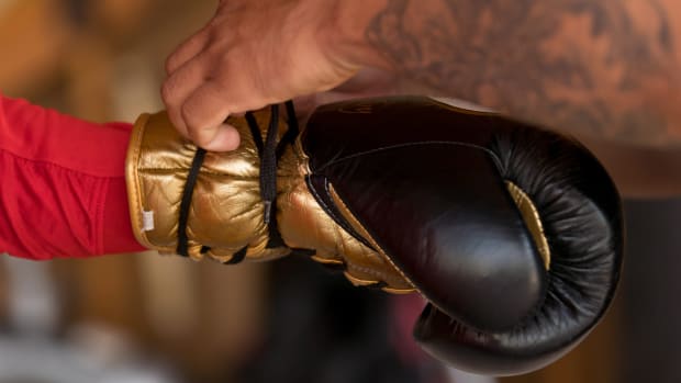 A boxer has a glove tied onto their hand.