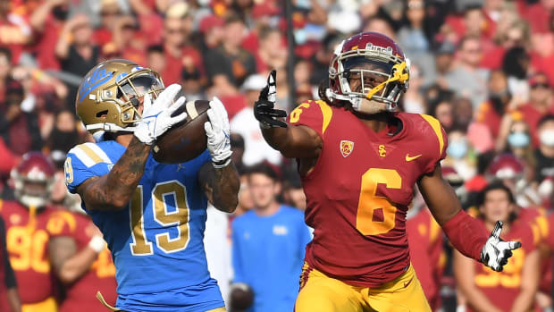 Nov 20, 2021; Los Angeles, California, USA; UCLA Bruins running back Kazmeir Allen (19) catches a touchdown pass against Southern California Trojans cornerback Isaac Taylor-Stuart (6) in the first half at the Los Angeles Memorial Coliseum. Mandatory Credit: Richard Mackson-USA TODAY Sports