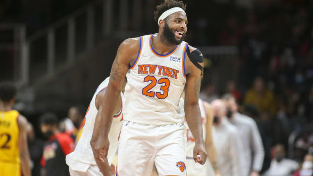 Knicks center Mitchell Robinson smiles during a timeout on the floor.