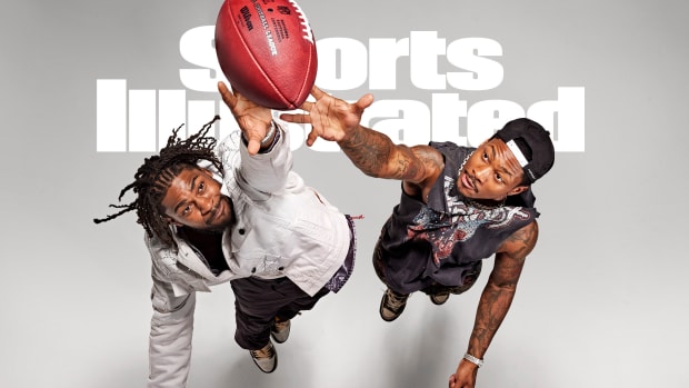 Trevon and Stefon Diggs leap for a football on the cover of the Sports Illustrated August 2022 issue