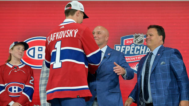 Jul 7, 2022; Montreal, Quebec, CANADA; Juraj Slafkovsky shakes hands with Montreal Canadiens general manager Kent Hughes after being selected as the number one overall pick to the Montreal Canadiens in the first round of the 2022 NHL Draft at Bell Centre.