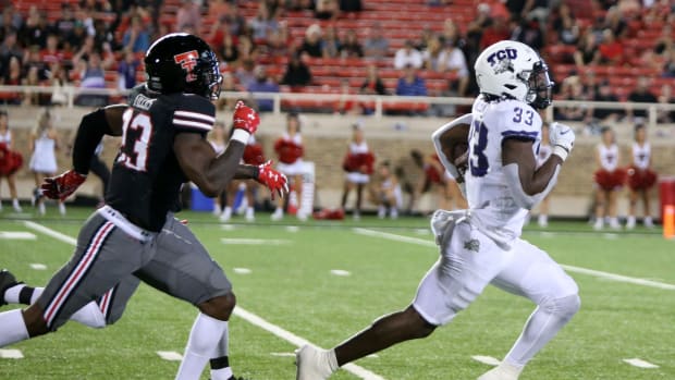 Oct 9, 2021; Lubbock, Texas, USA; Texas Christian Horned Frogs running back Kendre Miller (33) rushes for a touchdown against Texas Tech Red Raiders defensive corner back DaMarcus Fields (23) in the second half at Jones AT&T Stadium.