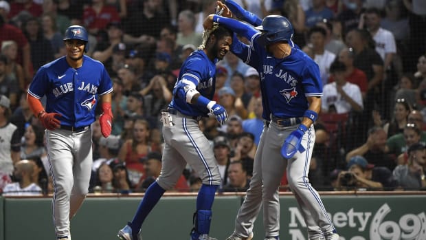 The Blue Jays celebrate at home plate after Raimel Tapia hits an inside-the-park grand slam.