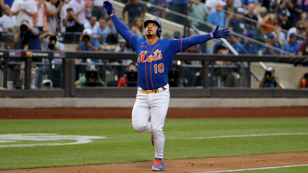 Mets third baseman Eduardo Escobar lifts his arms up in celebration as he rounds the bases after hitting a home run in the first inning against the Yankees.