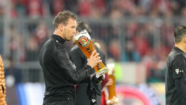 Julian Nagelsmann drinks beer from a giant glass after winning the Bundesliga as Bayern Munich manager in April 2022