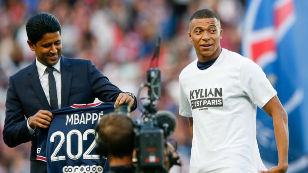 PSG president Nasser Al Khelaifi pictured (left) holding up a shirt printed with "Mbappe 2025" after Kylian Mbappe (right) signed a new contract