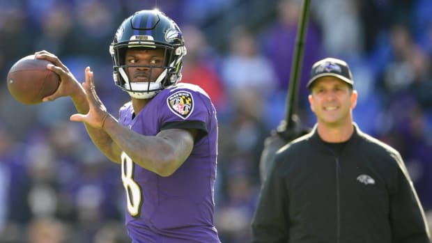 Baltimore Ravens quarterback Lamar Jackson (8) passes as head coach John Harbaugh looks prior to the game against the Los Angeles Chargers in the 2019 AFC Wild Card playoff game.