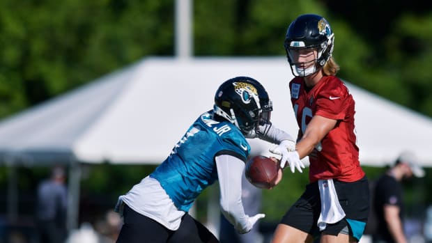 Jacksonville Jaguars quarterback Trevor Lawrence (16) makes a handoff play to running back Travis Etienne Jr. (1) during Wednesday’s training camp session.