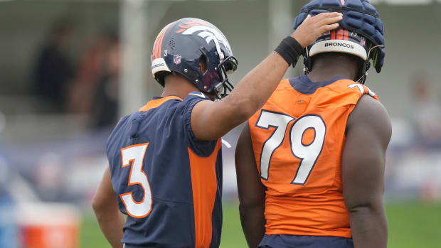 Denver Broncos quarterback Russell Wilson and center Lloyd Cushenberry (79) during training camp at the UCHealth Training Center.