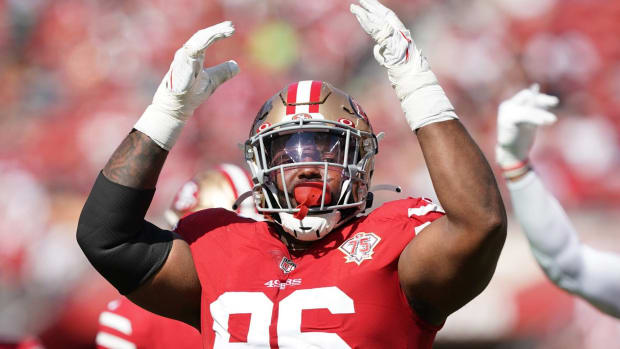 49ers defensive tackle Maurice Hurst raises his hands to pump up the crowd during a game.