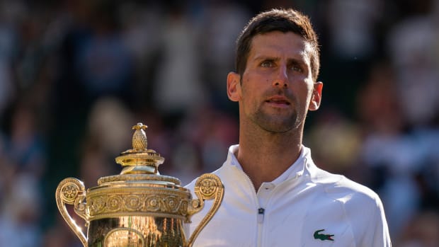Novak Djokovic (SRB) poses with the trophy after winning the 2022 Wimbledon men’s final against Nick Kyrgios.