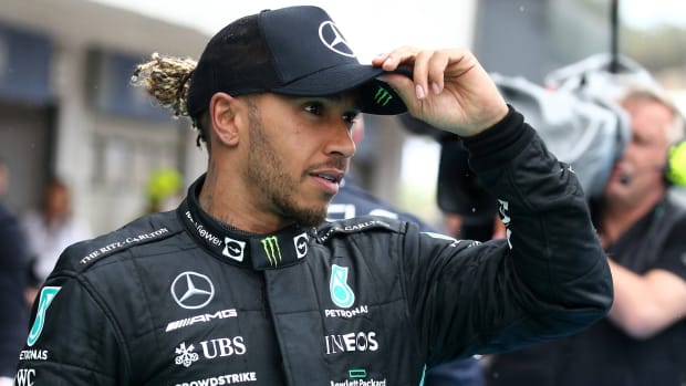 Mercedes F1 driver Lewis Hamilton holds onto his hat after finishing second at the Hungarian Grand Prix.