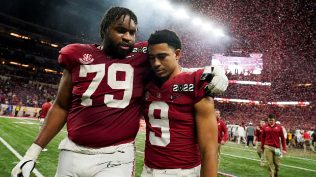 Alabama quarterback Bryce Young walks off with offensive lineman Chris Owens after losing the national championship game.