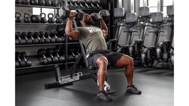 Man lifting dumbbells on adjustable weight bench