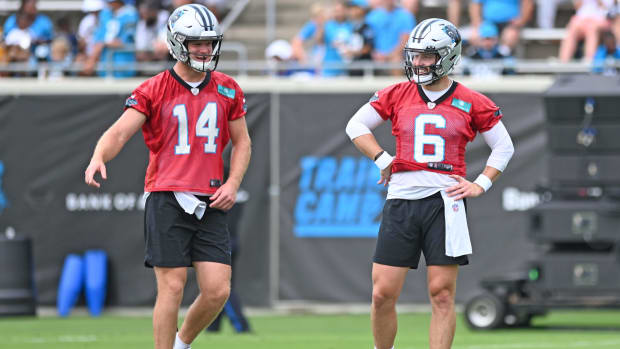 Panthers quarterbacks Baker Mayfield (6) and Sam Darnold (14) stand on the field during training camp practice.