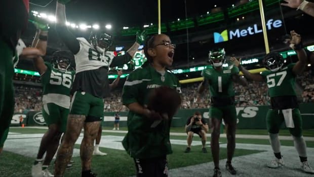 A.J., a kid with cerebral palsy, celebrates after scoring a touchdown in the Jets green and white scrimmage.