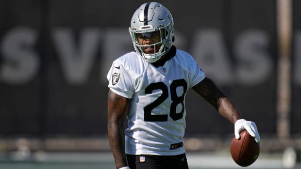 Raiders running back Josh Jacobs holds a football in his left hand during training camp practice.
